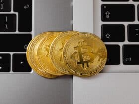 Close-up of Bitcoin coins resting on two laptop keyboards, representing digital currency and technology.