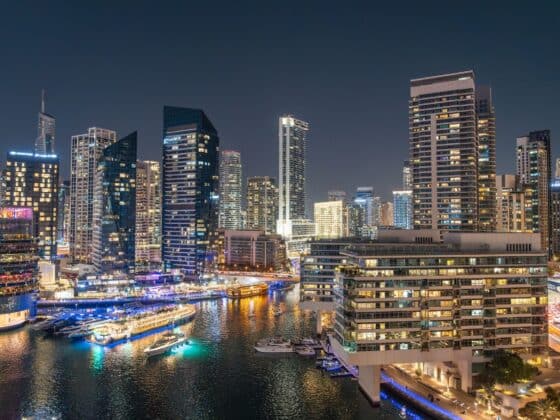 Stunning night view of Dubai Marina with illuminated skyscrapers and reflections on the water.