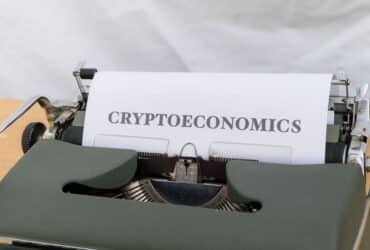 A vintage typewriter printing the term 'Cryptoeconomics', blending old technology with modern finance.
