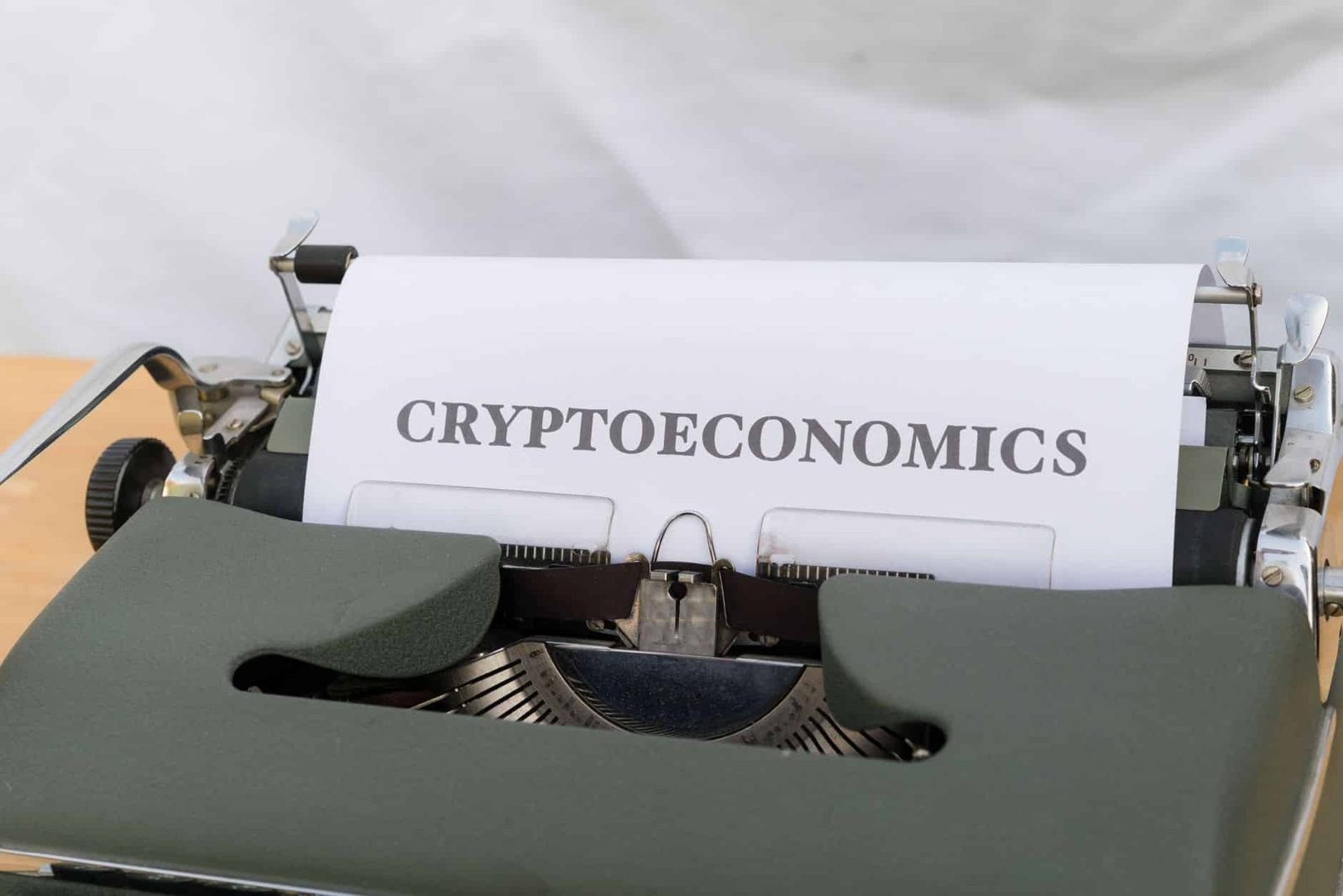 A vintage typewriter printing the term 'Cryptoeconomics', blending old technology with modern finance.