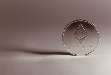 Close-up of a silver Ethereum coin symbolizing digital currency and blockchain technology.