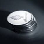 Close-up of stacked Ethereum coins on a dark textured surface, symbolizing modern cryptocurrency.