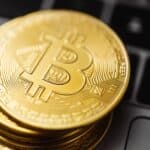 Close-up image of Bitcoin coins stacked on a laptop keyboard, symbolizing digital currency and blockchain technology.