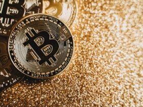 Close-up view of shining Bitcoin coins on a glittering golden background representing digital wealth.