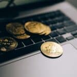Close-up of golden Bitcoins placed on a laptop keyboard, symbolizing digital currency and modern finance.