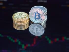 Close-up of bitcoin coins reflecting on a screen with financial market data, highlighting digital currency trend.