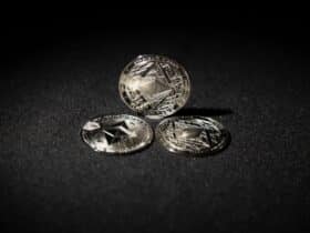Close-up of three Ethereum coins on a dark background, showcasing digital currency themes.