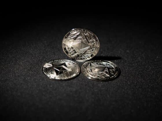 Close-up of three Ethereum coins on a dark background, showcasing digital currency themes.