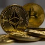 Detailed close-up shot of Ethereum and Bitcoin gold coins with a blurred background, signifying cryptocurrency.