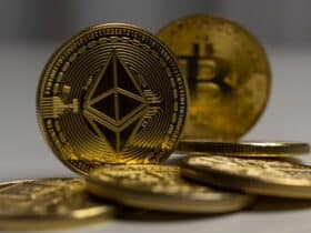 Detailed close-up shot of Ethereum and Bitcoin gold coins with a blurred background, signifying cryptocurrency.