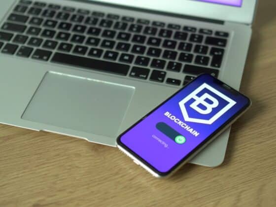 Smartphone displaying blockchain application resting on a laptop, symbolizing modern technology and finance.