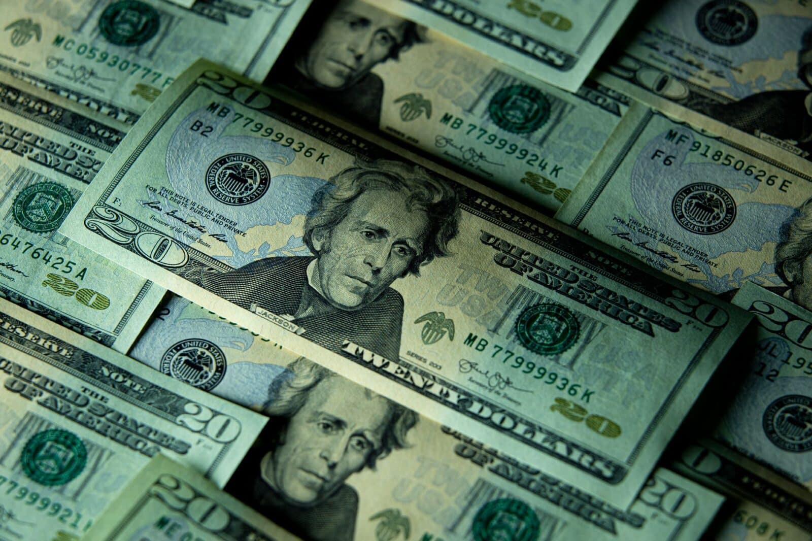 Close-up of multiple US twenty dollar bills depicting wealth and finance.