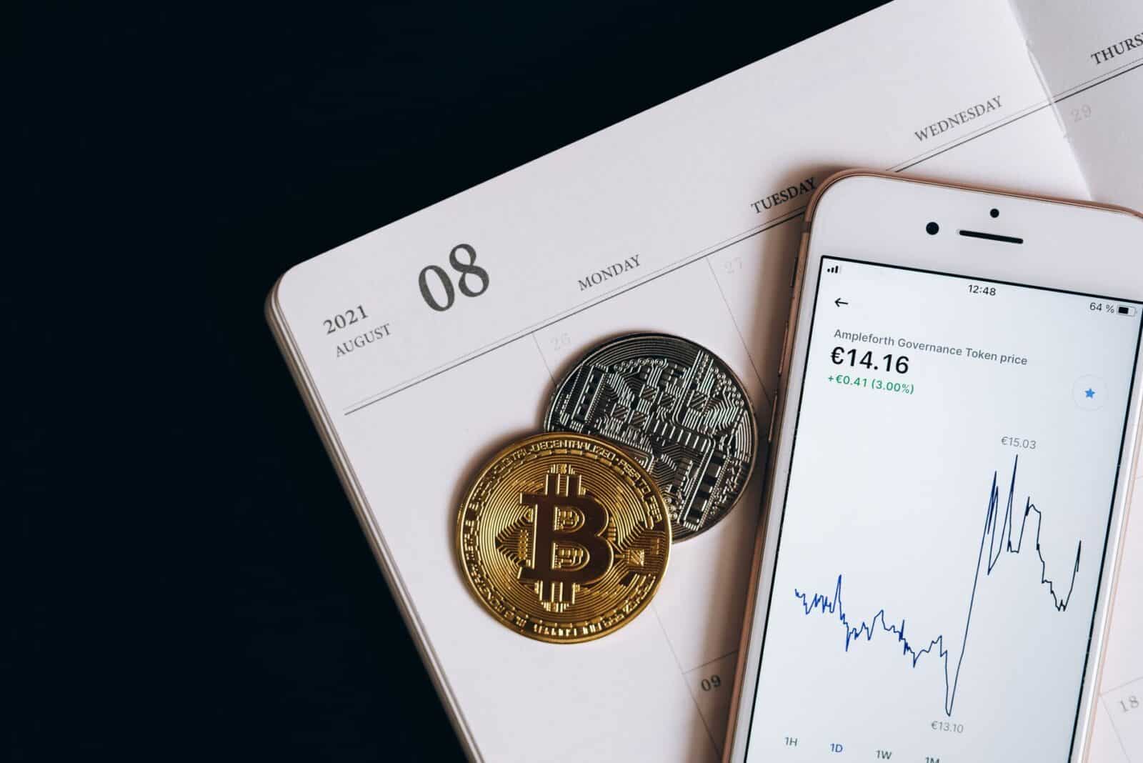 A smartphone displays cryptocurrency data alongside Bitcoin and Ethereum coins on an August calendar.