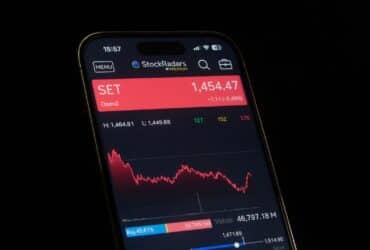 Close-up of a smartphone showing a stock market chart with financial data and analytics.