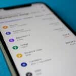 Close-up photo of a smartphone displaying cryptocurrency market data with price listings.