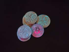 A detailed image showcasing a stack of Bitcoin cryptocurrency coins on a black background.