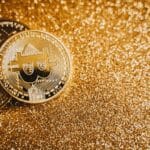 Close-up of bitcoins on a shimmering gold background, symbolizing digital wealth and investment.