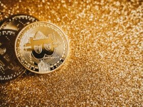 Close-up of bitcoins on a shimmering gold background, symbolizing digital wealth and investment.