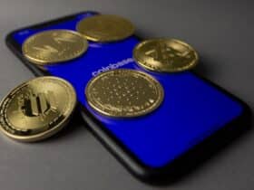 Five cryptocurrency coins displayed on a smartphone with Coinbase app open.