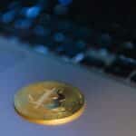 Close-up of a Bitcoin coin on a laptop, symbolizing digital currency and technology.