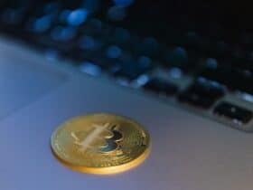 Close-up of a Bitcoin coin on a laptop, symbolizing digital currency and technology.