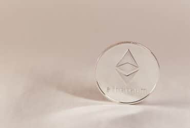 Close-up of an Ethereum coin on a soft, neutral background symbolizing modern cryptocurrency.