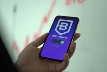 Hand holding smartphone displaying blockchain cryptocurrency wallet.