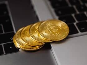 Close-up of golden bitcoins on a laptop keyboard representing digital currency and wealth.