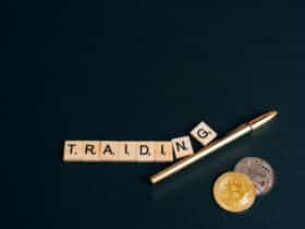 Bitcoin and trading concept shown with coins, pen, and letter tiles on a dark background.