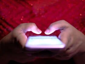 Close-up van handen die een cryptoadres intypen op een smartphone