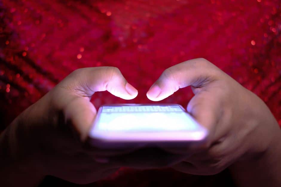 Close-up van handen die een cryptoadres intypen op een smartphone