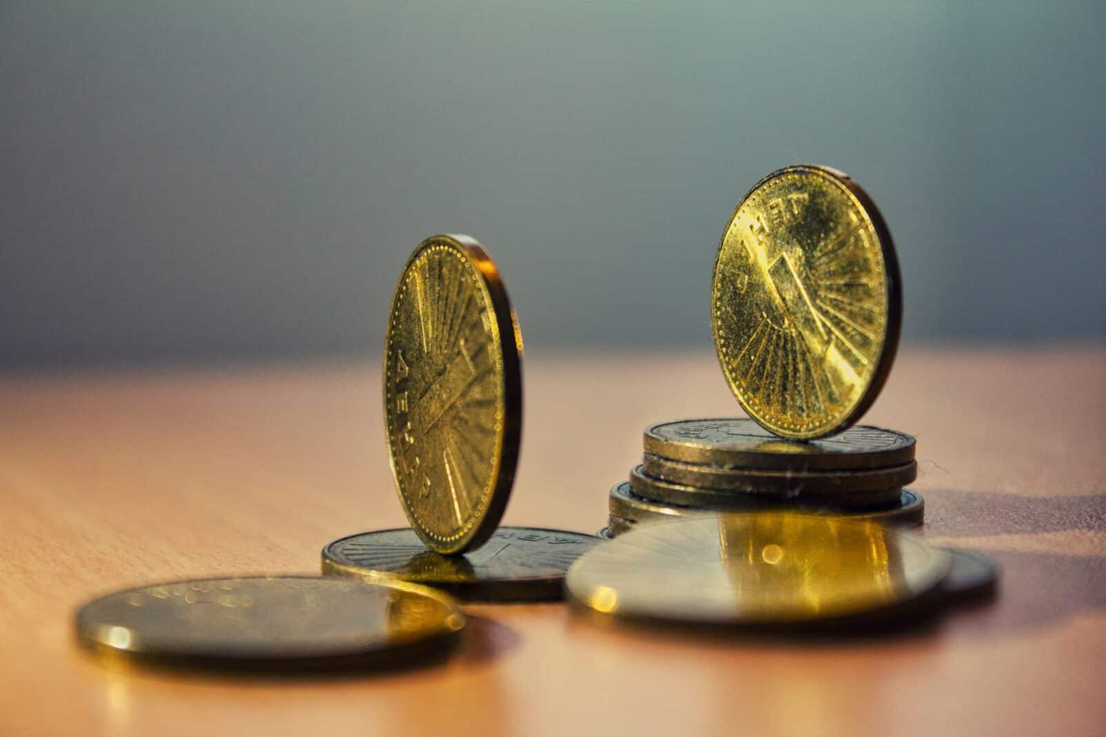 Close-up of North Macedonian denar coins on a bamboo table with artistic lighting.