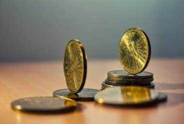 Close-up of North Macedonian denar coins on a bamboo table with artistic lighting.