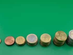 Various euro coins stacked incrementally on a vibrant green background.