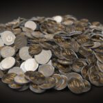A close-up view of a large pile of gold and silver cryptocurrency coins indicating financial wealth.