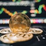 Golden Ripple XRP coins on laptop, symbolizing cryptocurrency trends and online trading.