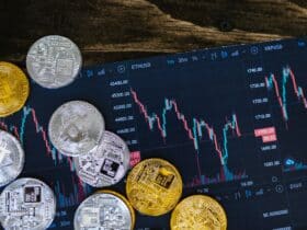 Close-up of gold and silver cryptocurrency coins on a digital trading chart.