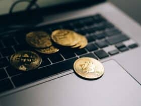 Close-up of golden Bitcoins placed on a laptop keyboard, symbolizing digital currency and modern finance.