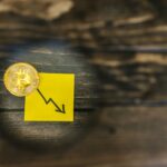 A gold Bitcoin and downward trend arrow symbolizing cryptocurrency market decline.