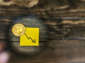 A gold Bitcoin and downward trend arrow symbolizing cryptocurrency market decline.