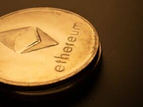 Detailed macro shot of an Ethereum logo coin against a dark background.