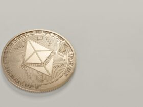 A golden Ethereum coin placed on a neutral light background, symbolizing digital currency.