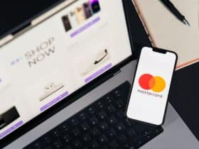 Laptop and smartphone with Mastercard logo, illustrating online shopping and digital payments.